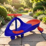 בימבה לילדים בצבע אדום וכחול עם גלגלים קטנים, על שביל בגינה | yrz