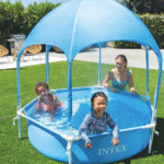 בריכת ילדים עגולה עם גגון כחול, עם ילדים במים בחצר | yrz