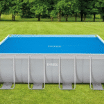 בריכה מלבנית INTEX עם כיסוי סולארי כחול מעל המים על רקע דשא | yrz