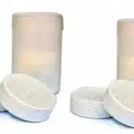 טבליות כלור עגולות ליד מיכלי פלסטיק לבנים | yrz