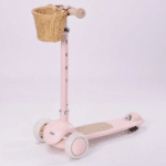 קורקינט ילדים בצבע ורוד בסגנון וינטג' עם סלסלת קש מקדימה, על רקע לבן | yrz