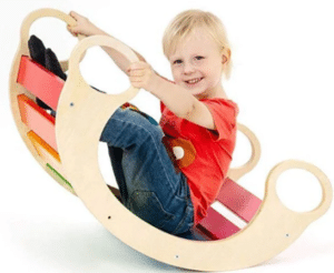 ילד יושב על נדנדת עץ צבעונית בצורת סהר עם ידיות | yrz