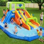 ילדים משחקים בפארק מים מתנפח עם שתי מגלשות ובריכת מים בחצר | yrz